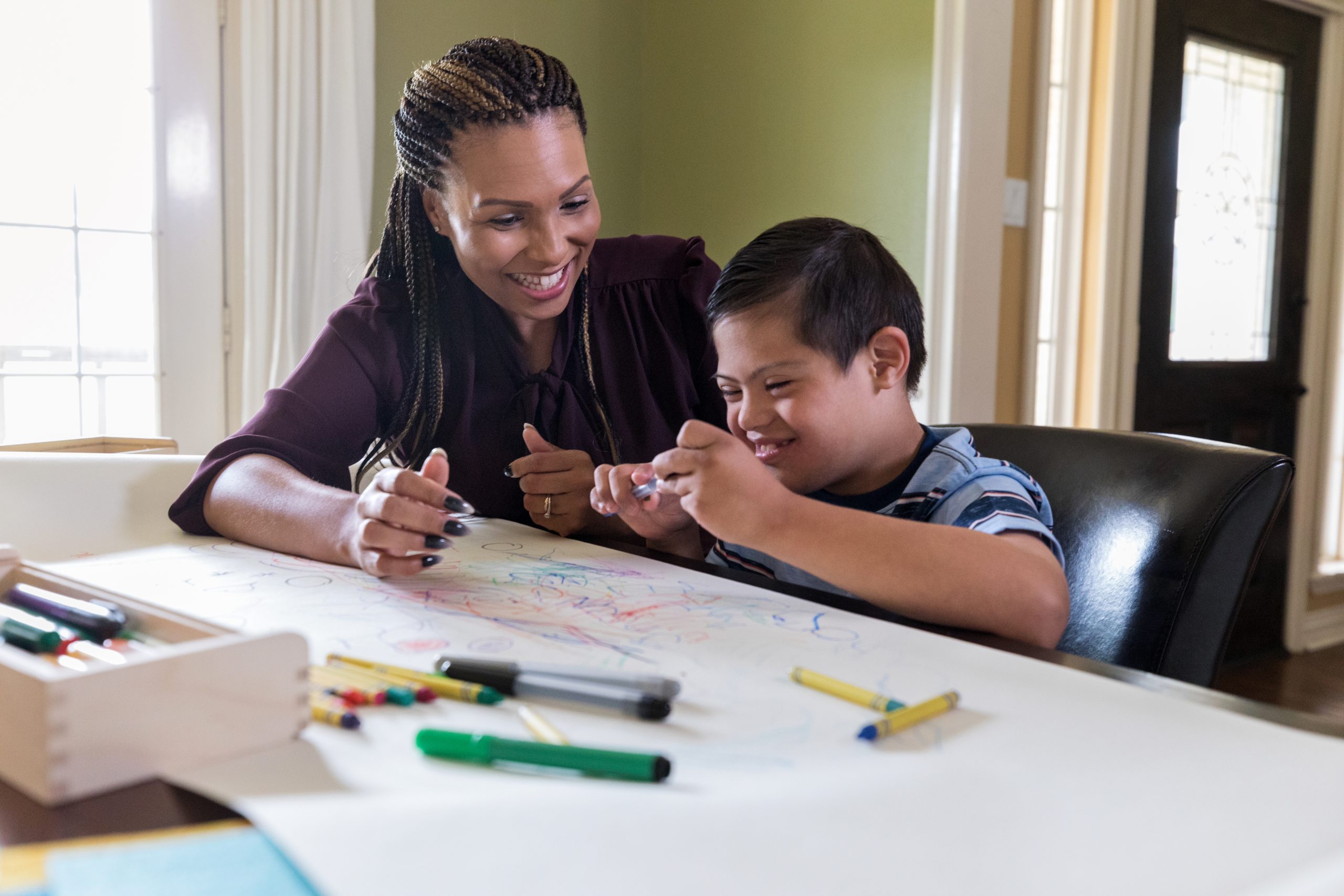 Therapist encourages special needs boy as he learns new skill