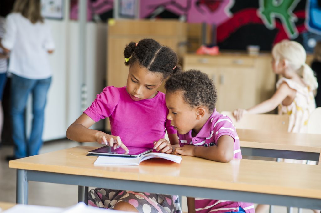 Boy and girl using digital tablet in classroom